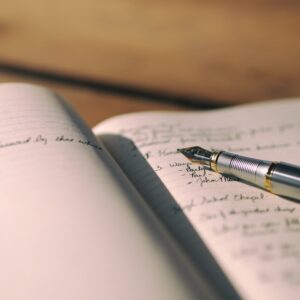 Aufgeschlagenes Buch mit Füller und beschriebenen Seiten
